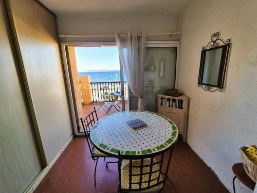 une pièce avec une table et une vue sur l'océan dans l'établissement Pleine vue mer, à 10 m plage de sable, au Brusc, Terrasse..., à Six-Fours-les-Plages