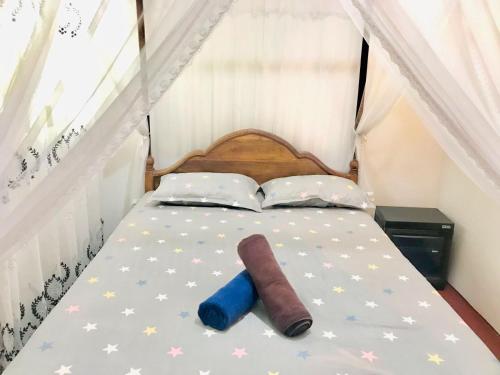 a bed with a book and a sock on it at Dinesh House in Weligama