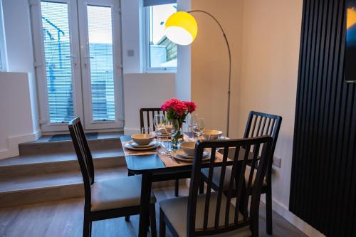 a dining room with a table with chairs and a lamp at Sunbeam House 1 Morecambe Pet Friendly in Morecambe