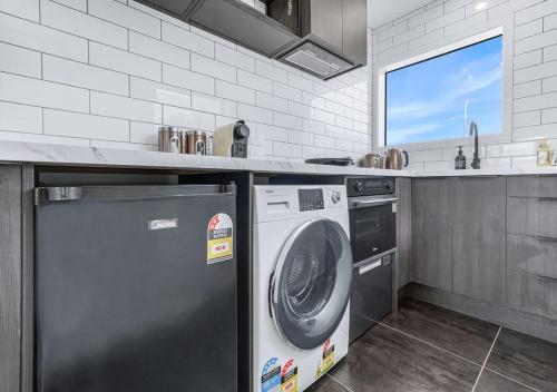 a kitchen with a dishwasher and a washing machine at Inner City Location, Modern & Stylish #6 -By KOSH BNB in Hamilton