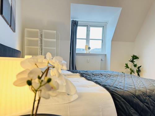 a bedroom with a bed with white flowers on it at aday - Starlight 2 bedrooms Apartment in the Heart of Aalborg in Aalborg
