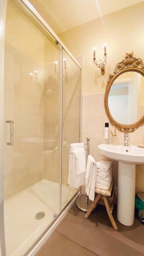 a bathroom with a shower and a sink and a mirror at Palazzo Lari Sarzana - Historic Boutique Rooms in Sarzana