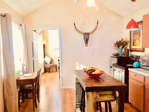 a kitchen with a table with a bowl of fruit on it at Charming Garden Cottage in Eugene