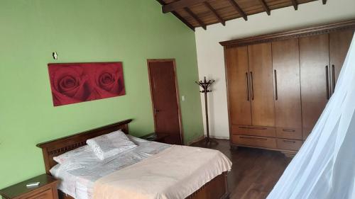 1 dormitorio con 1 cama con una pintura roja en la pared en Casa confortável, en Pelotas