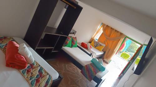 a small bedroom with a bed and a window at Alojamiento el jardin in Filandia