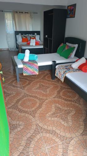 a living room with two beds and a carpet at Alojamiento el jardin in Filandia
