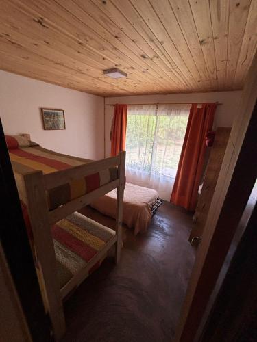a small bedroom with a bed and a window at La Rosadita in Necochea