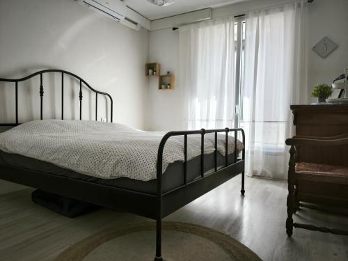 une chambre avec un lit noir et une fenêtre dans l'établissement L'échappée belle, parking, climatisation, 5min à pied du centre historique, à Avignon