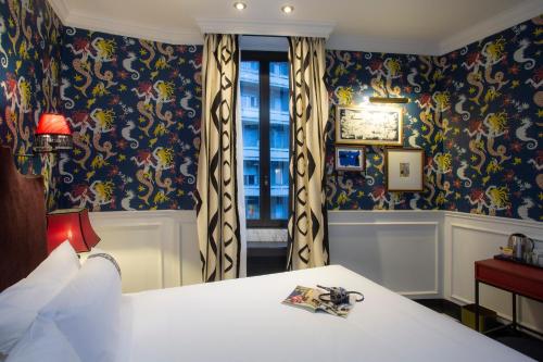 a bedroom with a bed and a window with floral wallpaper at Casual Eclettico Milano in Milan