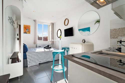 une cuisine avec un évier et un comptoir avec des tabourets dans l'établissement Cocon Place Massena, Cours Saleya et Mer, à Nice