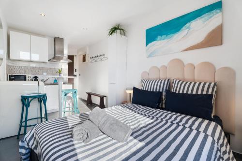 une chambre avec un lit à rayures bleues et blanches dans l'établissement Cocon Place Massena, Cours Saleya et Mer, à Nice