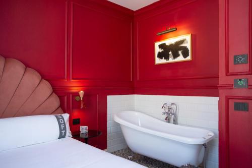 a red bathroom with a tub and a sink at Casual Eclettico Milano in Milan