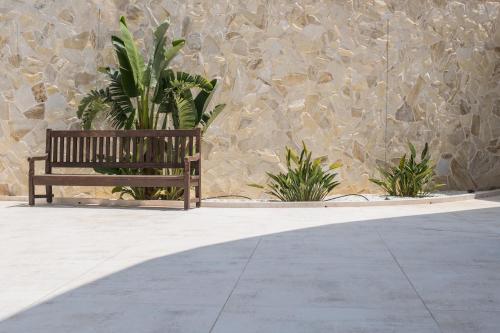 a wooden bench sitting in front of a stone wall at Exclusiv one in Torrox