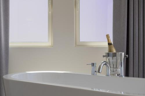 a bathroom with a tub and a bottle of champagne at Exclusiv one in Torrox