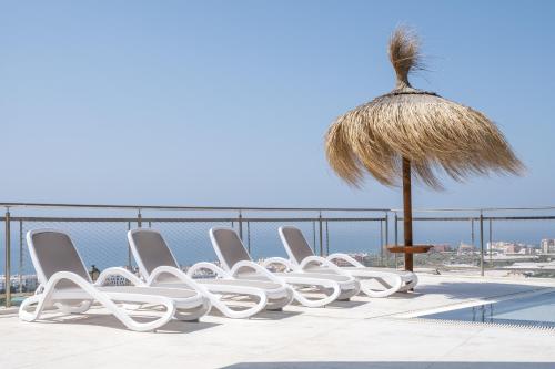 a row of white chairs sitting on top of a roof at Exclusiv one in Torrox