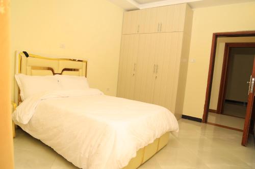 a bedroom with a large bed with white sheets at My dream apartment in Addis Ababa