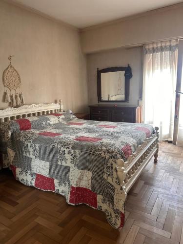 een slaapkamer met een bed met een dekbed erop bij Linda in Mar del Plata
