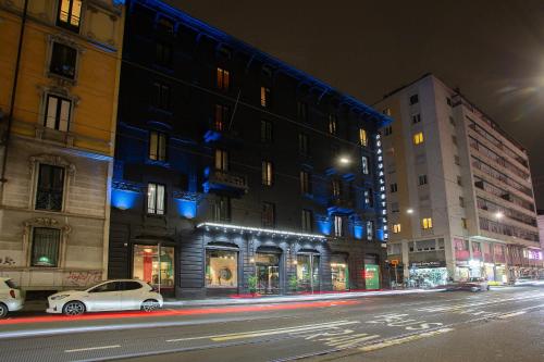 a city street at night with buildings and cars at Casual Eclettico Milano in Milan