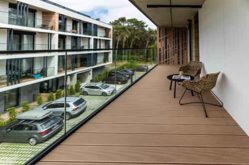 an apartment balcony with a view of cars at Apartamenty na Półwyspie Wydma&Las in Jastarnia