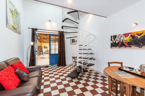 a living room with a spiral staircase and a table at Domaine des Ecoliers - Appartement 123 soleil - Parking in Montaigu-Vendée