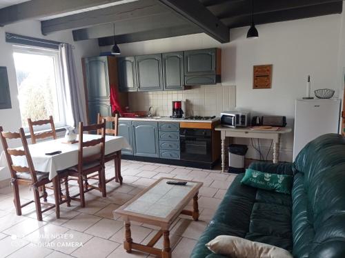 un salon avec un canapé et une table et une cuisine dans l'établissement Gite la Ville Brunet, à Saint-Briac-sur-Mer