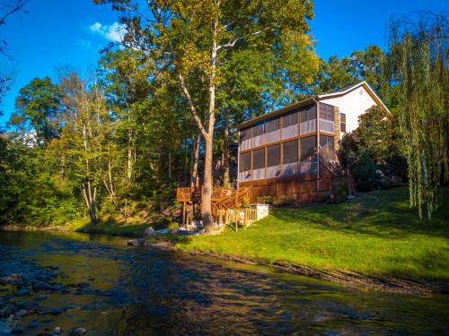 a house sitting on the side of a river at Crystal Waters in Pigeon Forge