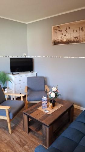 a living room with a coffee table and a tv at Glücksburg Strandnah an der Förde in Glücksburg