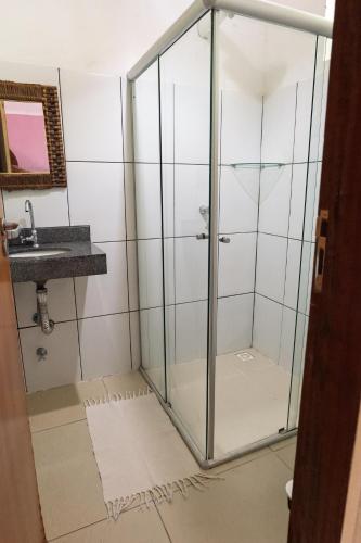 a shower with a glass door in a bathroom at Villa Residencial Encantos Da Mata in Itacaré