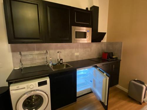 a kitchen with a washing machine and a microwave at Rotterdam Inn in Rotterdam