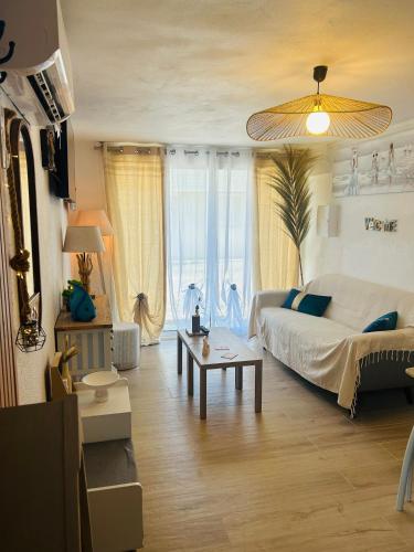 un salon avec un lit et une table dans l'établissement Bas de Chalet Santa Giulia, à Gruissan