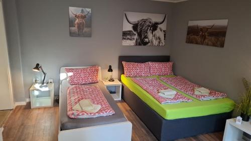 a bedroom with two beds and a cow on the wall at Glücksburg Strandnah an der Förde in Glücksburg