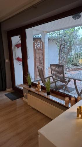a living room with a patio with a chair and a table at Glücksburg Strandnah an der Förde in Glücksburg