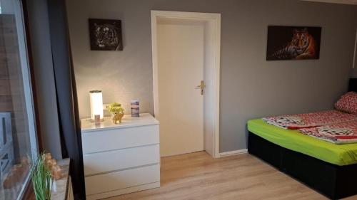a bedroom with a bed and a dresser and a door at Glücksburg Strandnah an der Förde in Glücksburg