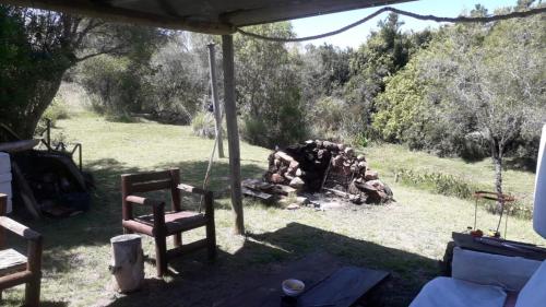a fire pit in a yard with two chairs at cabaña sin luz en campo in San Carlos