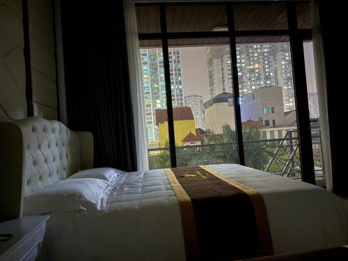 a bedroom with a bed and a large window at Nhà nghỉ QT Nam Khánh in Hanoi
