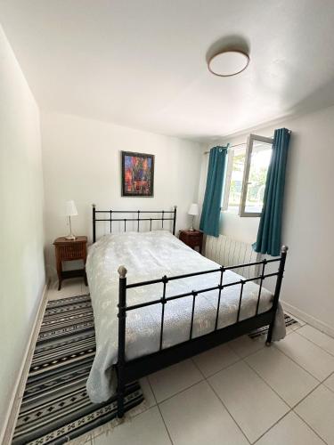 une chambre avec un lit et une fenêtre avec des rideaux bleus dans l'établissement Maison dans parc privé, sports et loisirs proche golf du Coudray Montceaux, à Le Coudray-Montceaux