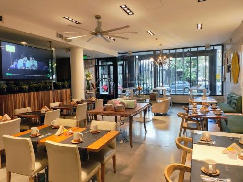 a restaurant with tables and chairs and a flat screen tv at Be Hollywood! in Buenos Aires