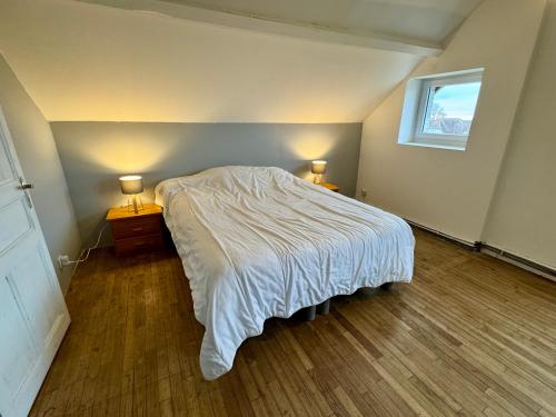 une chambre avec un lit avec deux tables de nuit et une fenêtre dans l'établissement Maison individuelle à deux pas du château de Pompadour et de l'hippodrome !, à Arnac-Pompadour