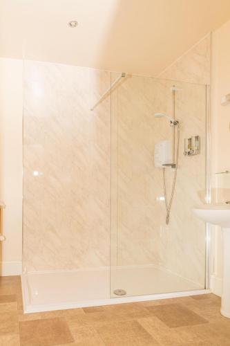 a shower with a glass door in a bathroom at Whittonlodge sleeps28 Hottub pool table in Hardstoft