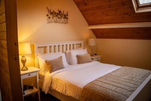 a bedroom with a bed with white sheets and pillows at Anglers Arms in Alnwick