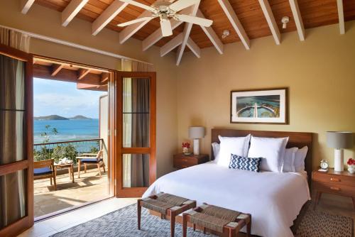 a bedroom with a bed and a view of the ocean at Rosewood Little Dix Bay in Virgin Gorda Airport