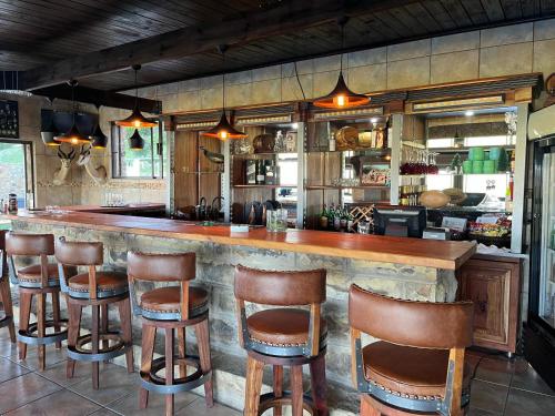 a bar with wooden stools in a restaurant at Uitzicht Private Nature Reserve and Lodge in Fouriesburg