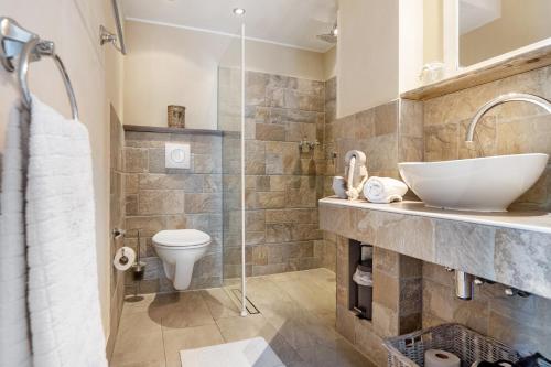 a bathroom with a sink and a toilet at GÄSTEWOHNUNGEN AM SEE "Maisonette & Suite" in Neuenkirchen