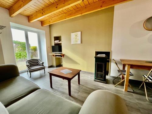 a living room with a couch and a fireplace at Theven Plages in Santec