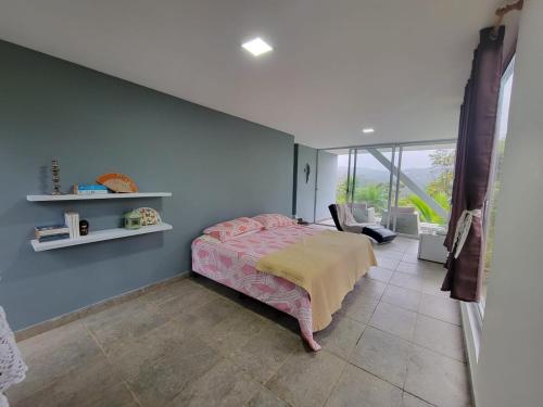 a bedroom with a bed and a blue wall at Naturaleza, Flora y Fauna in Los Altos de Cerro Azul