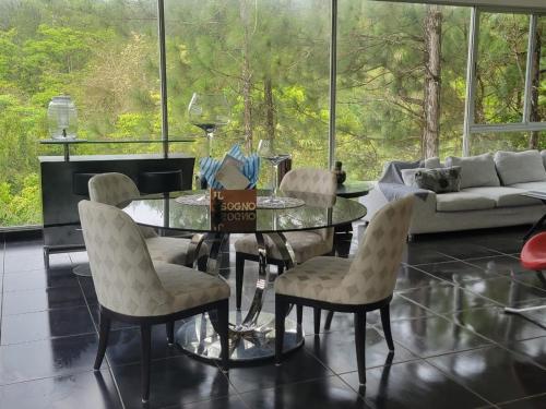 a dining room with a glass table and chairs at Naturaleza, Flora y Fauna in Los Altos de Cerro Azul
