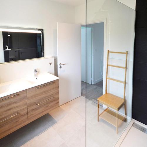 La salle de bains est pourvue d'un lavabo, d'une échelle et d'une chaise. dans l'établissement La Villa Mana, à La Forêt-Fouesnant