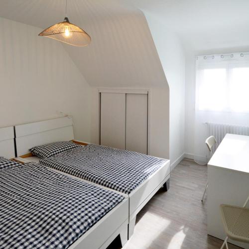 - 2 lits dans une chambre blanche avec une lampe dans l'établissement La Villa Mana, à La Forêt-Fouesnant