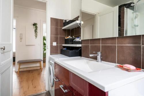 une cuisine avec un évier et une machine à laver dans l'établissement Nice and cozy parisian apartment, à Paris