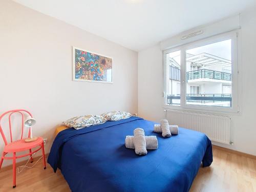 a bedroom with a blue bed and a red chair at Lingo104 - Confort - Proche centre ville - Transports en communs in Lingolsheim